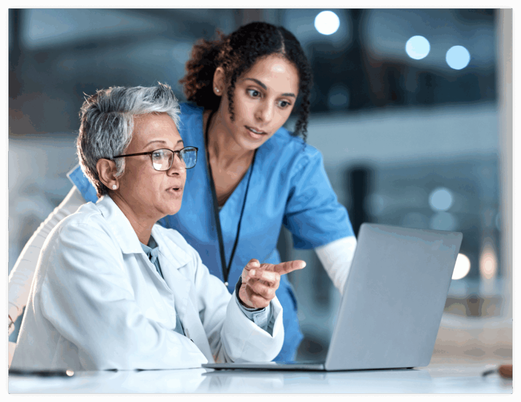 Two medical professionals looking at a laptop.