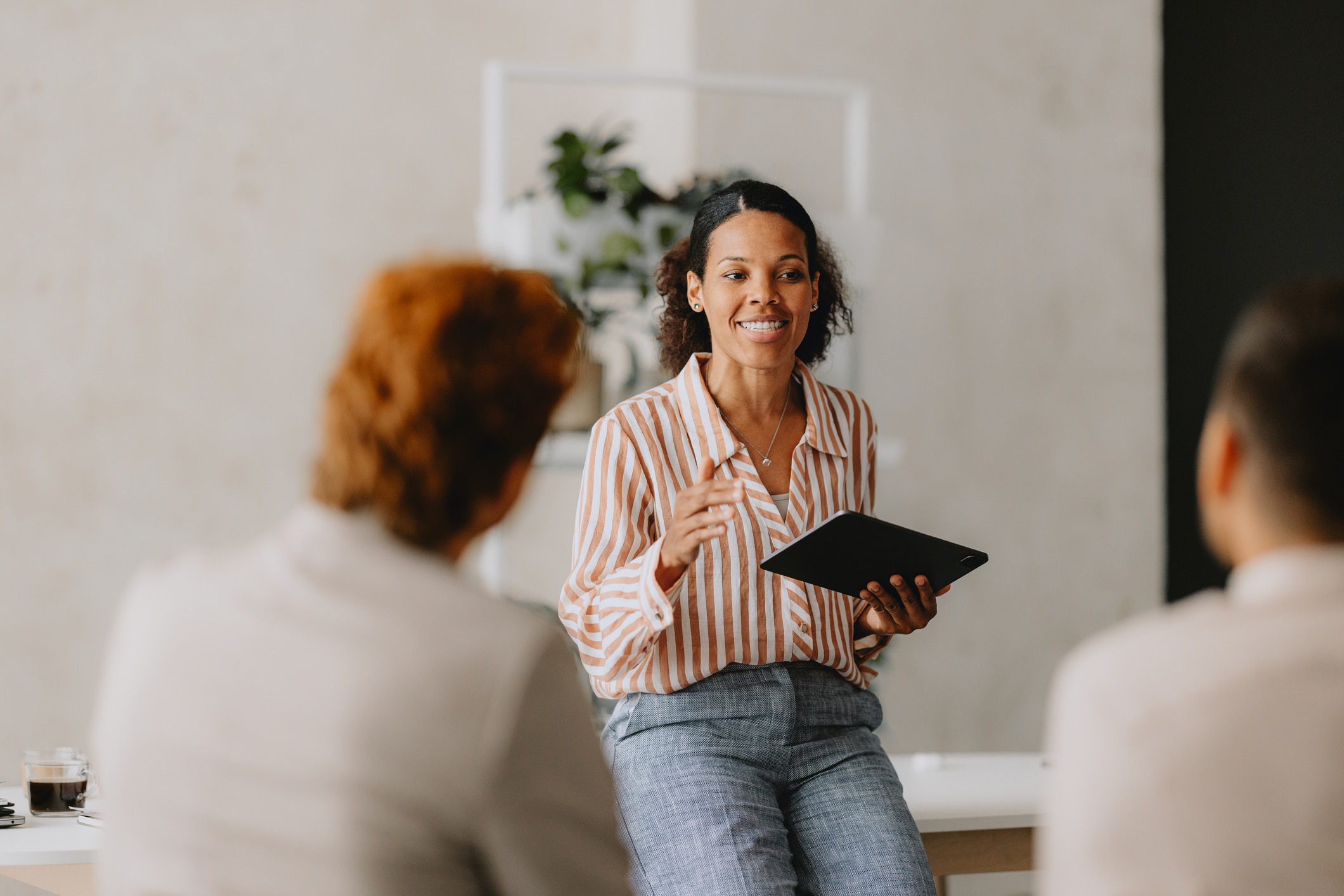 Confident businesswoman leading a group business meeting at an office.