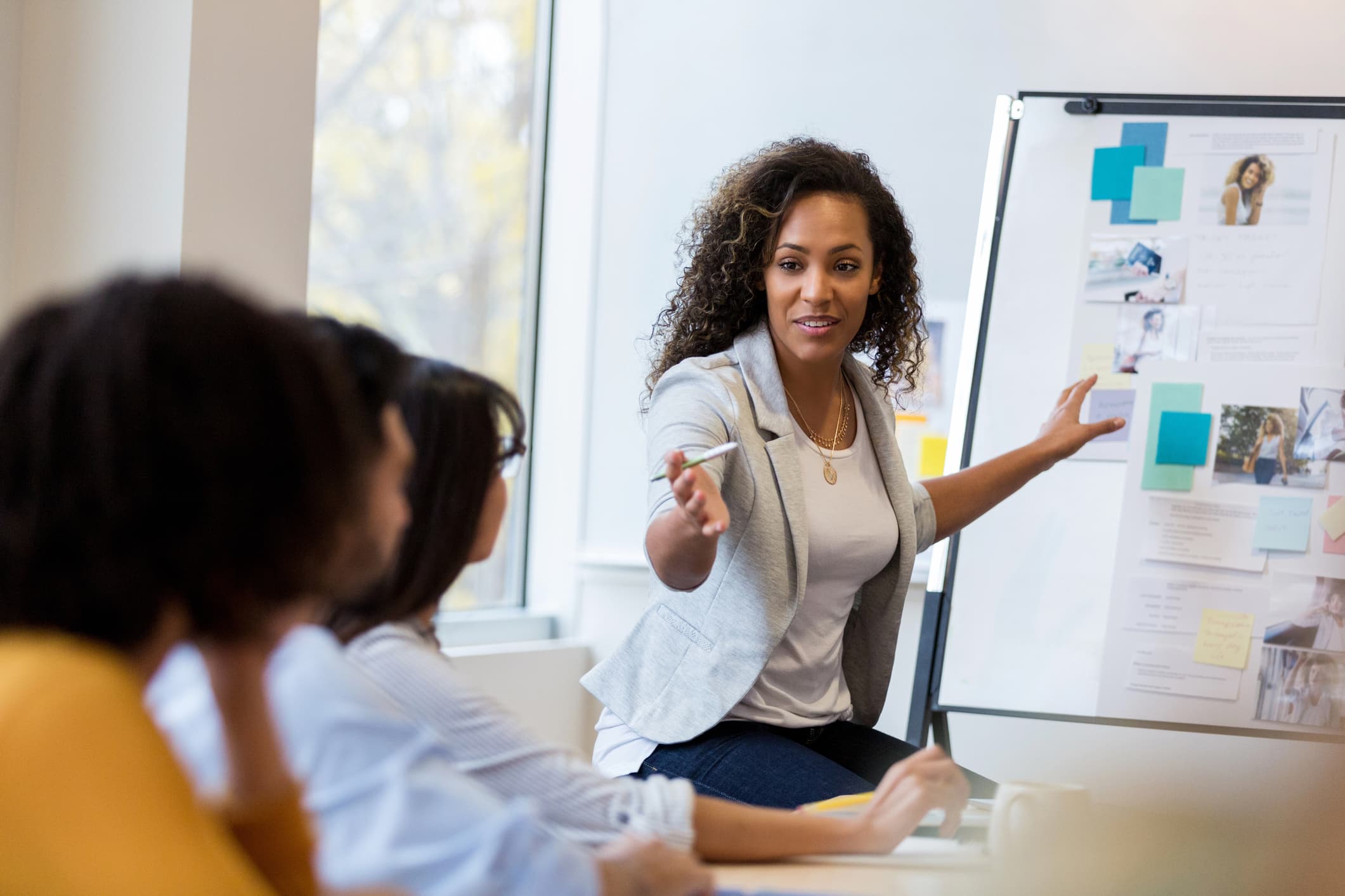 Instructor referencing information on a whiteboard while teaching a room of adult learners