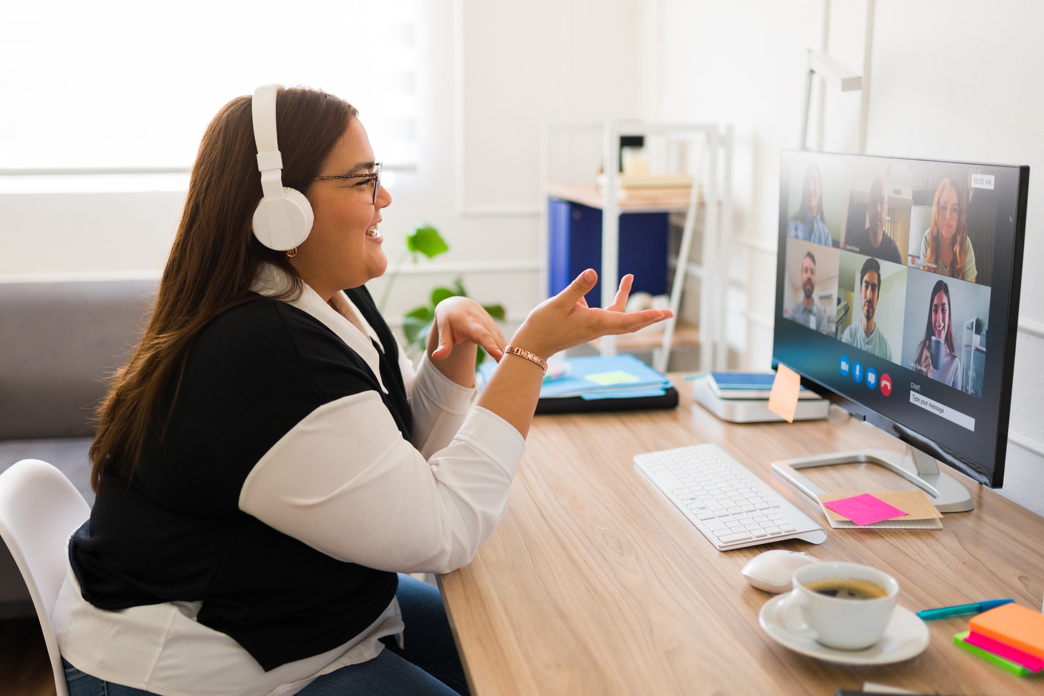 Professional woman with headphones talking during an online video call