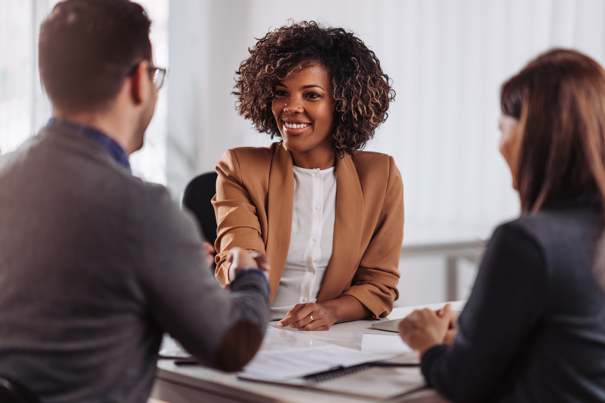 Business people shaking hands and smiling after a meeting